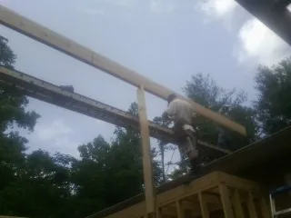 Carpenter setting a ridge beam over a new addition frame — Ice Dam Removal by Roofing Brothers in Mount Tabor