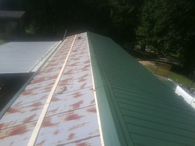 Old rusted panels beside newly installed green metal roofing — Wind Damage Roof Repair by Roofing Brothers in Mount Tabor
