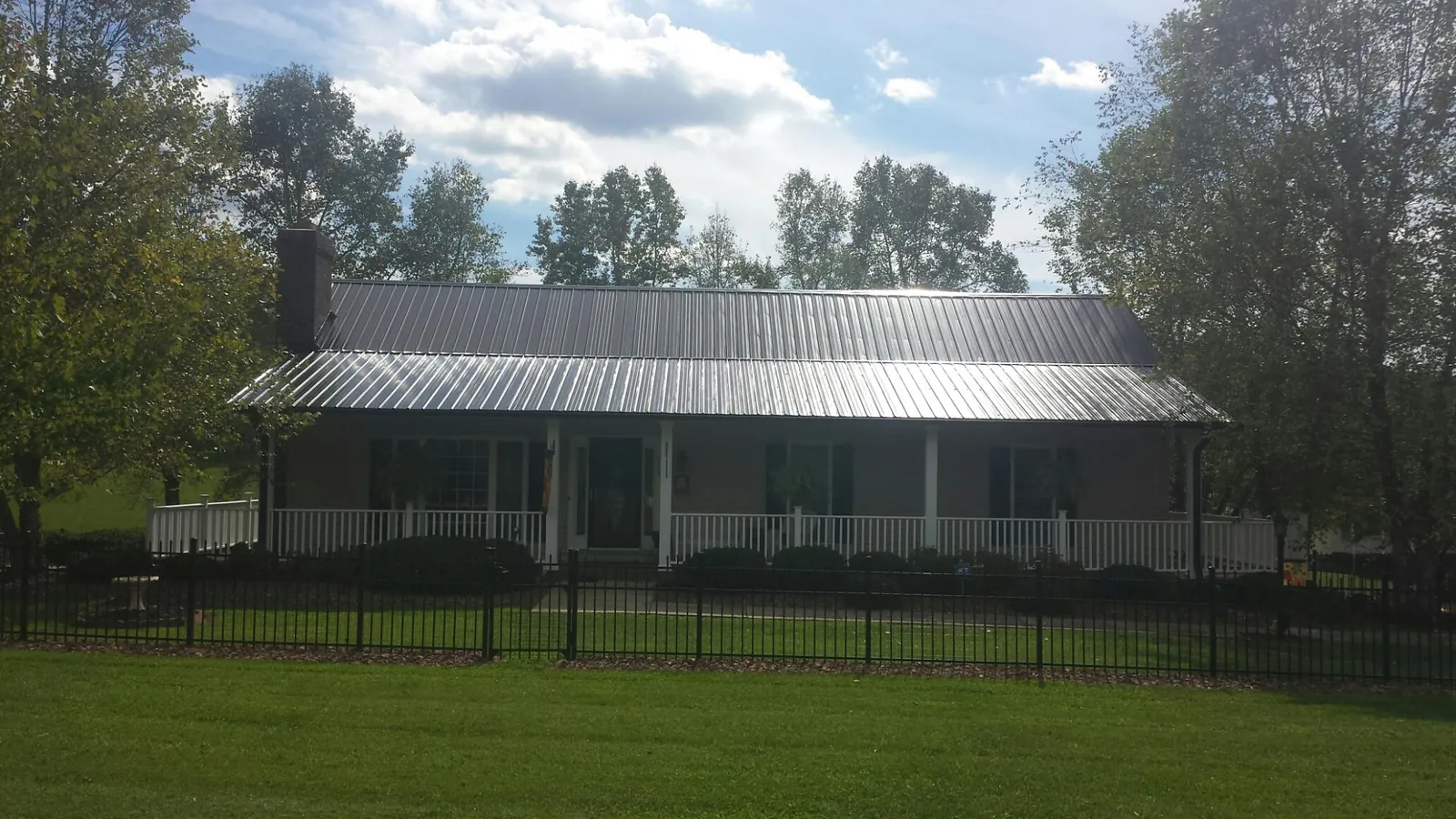 Gray metal roof on a brick ranch with a full width front porch — Gutter Guard Installation work by our crew in Mount Tabor