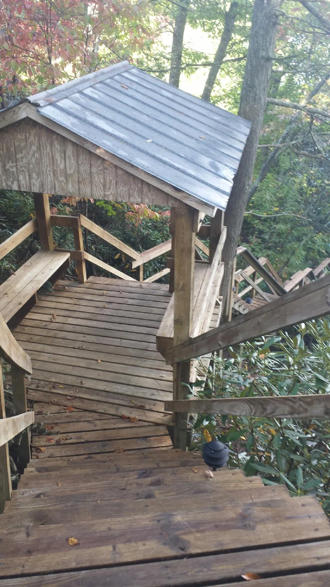Metal roofed shelter over wooden steps on a wooded walkway — Skylight Repair & Installation work by our crew in Mount Tabor