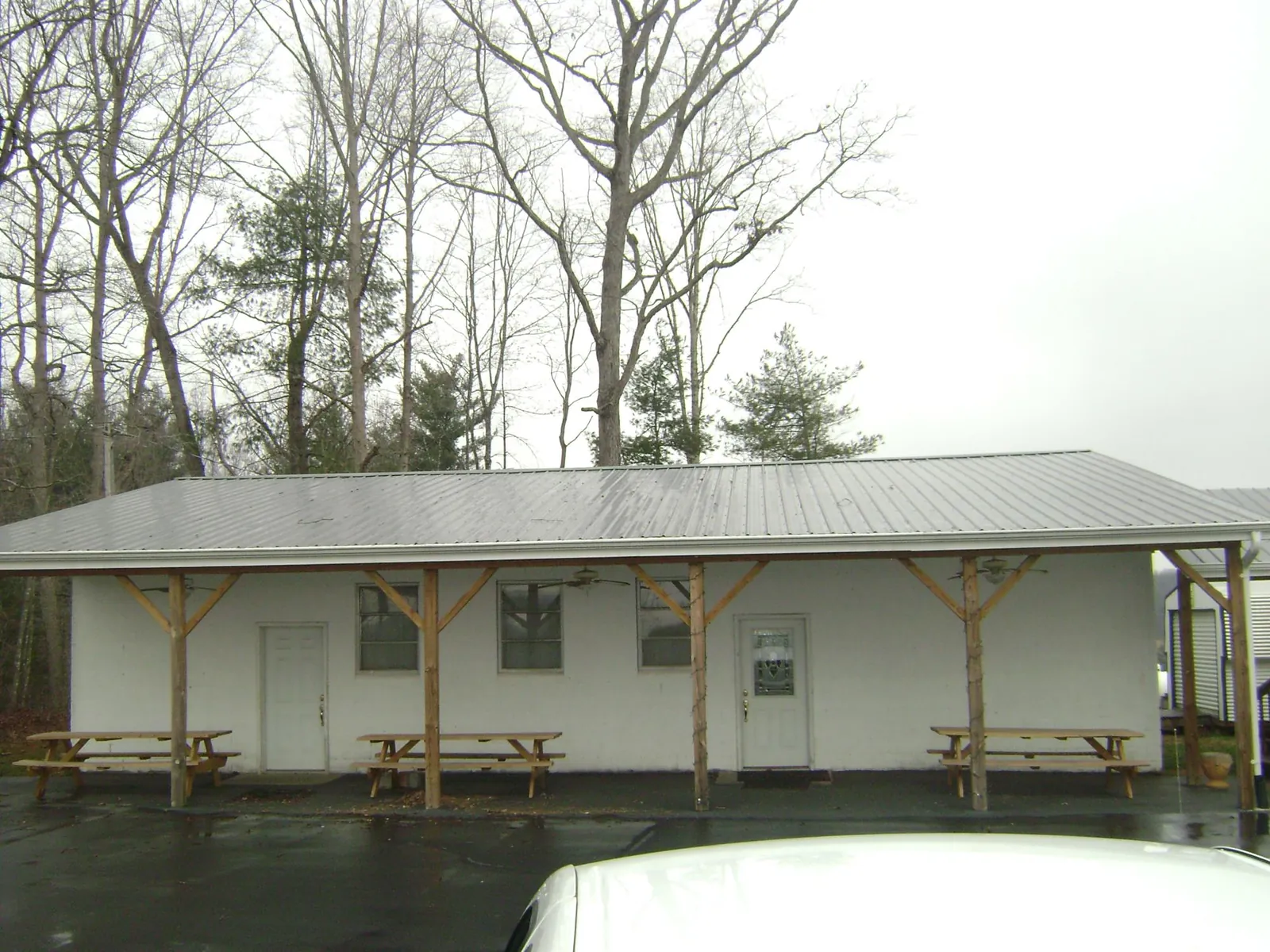 Gray metal roof over a block building with a timber post porch in Mount Tabor
